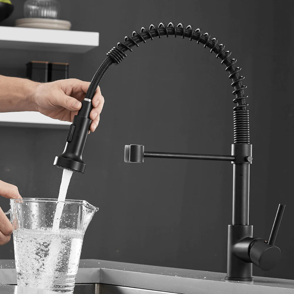 Using Halmstad pull-out kitchen faucet to fill a cup of water in a luxurious kitchen