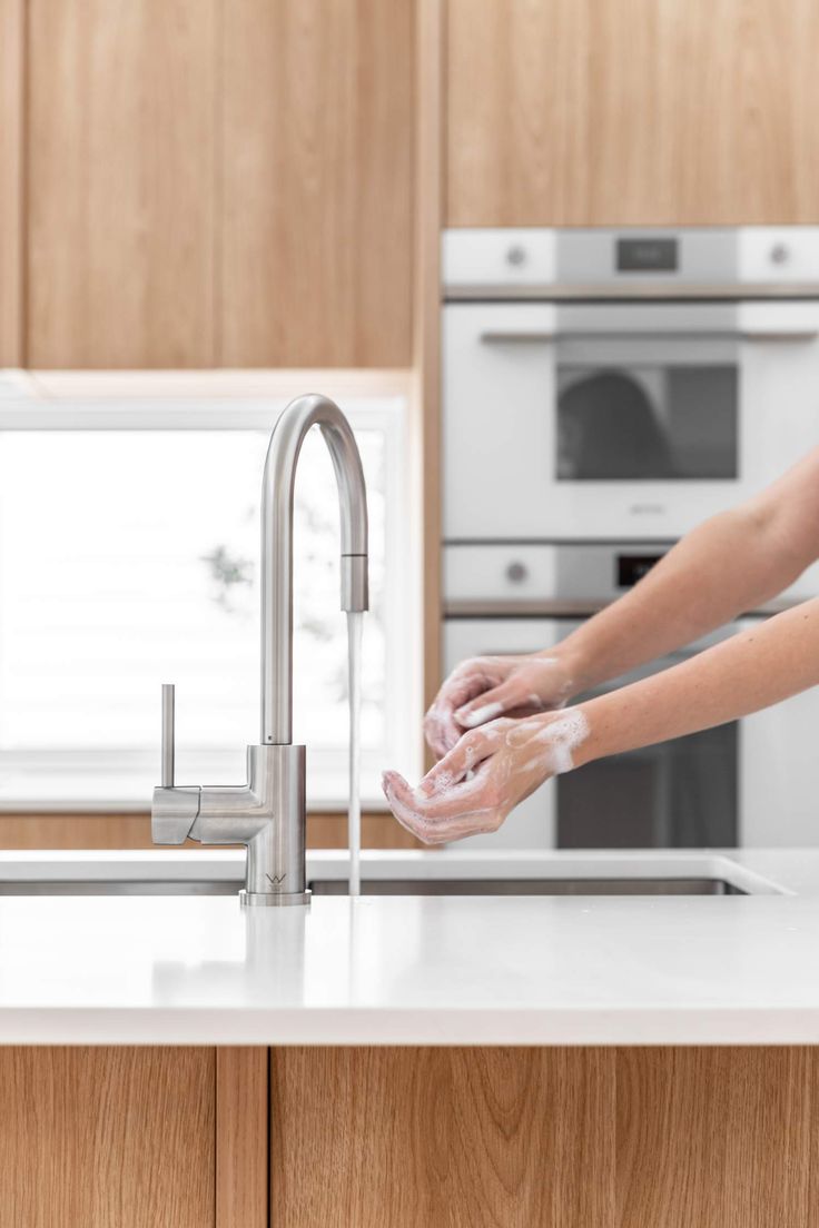 Washing hands with a premium faucet in a luxurious kitchen